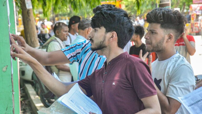 Candidates check notice board for their allotted seats before appearing for the NEET exam, at an examination centre in Moradabad. (PTI)